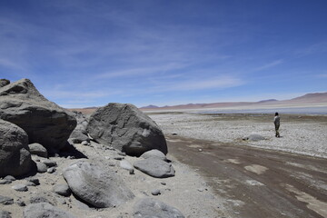 Uyuni, Bolivia - 10 february 2017: A tourist passes near the stones. Off-road tour on the salt flat Salar de Uyuni