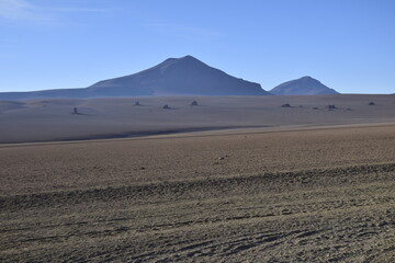Sandy road through the desert at sunrise in Eduardo Avaroa National Reserve in Uyuni, Bolivia.