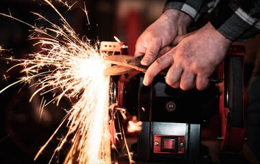 The process of sharpening scissors on metal with the release of a large number of bright sparks