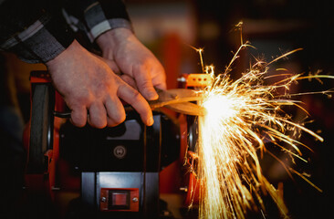 The process of sharpening scissors on metal with the release of a large number of bright sparks