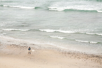Surfer walking on the ocean beach