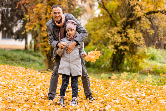 young father and little girl walking in autumn park