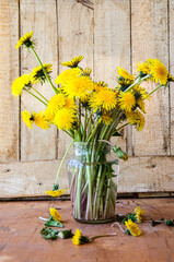 Spring bouquet of dandelions in a glass vase.