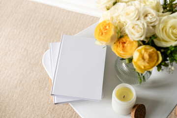 White book blank cover mockup on stylish chair with roses bouquet, high angle view