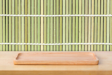 Empty sushi board on wood table with bamboo background. Top view of plank wood for graphic stand product, interior design or montage display your product.