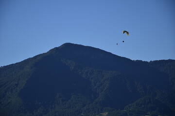 A paraglider flies over the mountains. Pucon Chile