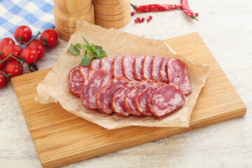 Sliced salami sausages over board