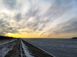 Smoke from the plant in the sky at sunset
