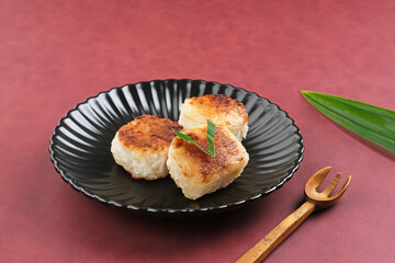 Wingko or Wingko Babat, a traditional Indonesian snack made from grated young coconut, glutinous rice flour, and sugar. Selected focus.

