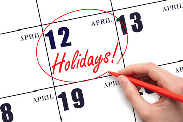 Hand drawing a red circle and writing the text Holidays on the calendar date 12 April. Important...