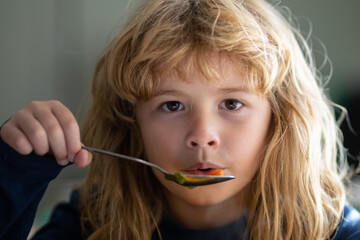 Child have a breakfast. Tasty kids breakfast. Adorable little school boy eating vegetable soup...