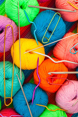 All for hand knitting. Knitted multi-colored handmade fabric with balls of multi-colored threads,...