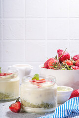 Sweet matcha strawberry dessert. Breakfast layered parfait dessert with yogurt, matcha green tea sponge biscuit and fresh strawberry, white background copy space