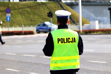 Policjant policji drogowej podczas nadzoru ruchu drogowego z radiowozem.  - obrazy, fototapety, plakaty
