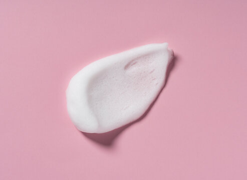 Skincare cleanser foam texture. Swatches of soap, shampoo and cleansing mousse foam with copy space on pink background.