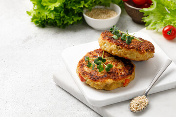 Delicious vegetarian cutlets made with quinoa, vegetables and microgreens on marble board. Copy space