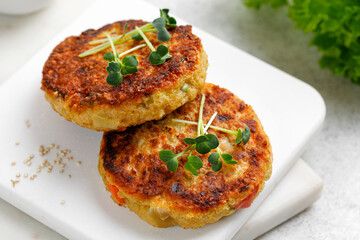 Vegan cutlets made with quinoa and vegetables, served with microgreens. Delicious vegan food. Close-up