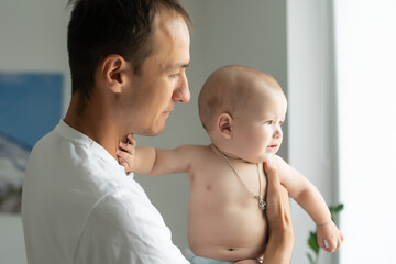 Happy young man holding a smiling 6 months old baby