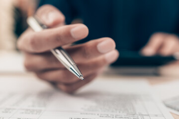 Investors working on desk office and using a calculator to calculate balance, projit, currency and...