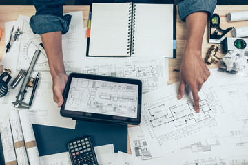 Architect engineer use tablet to read drawing design. House planning design and construction...