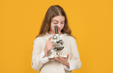 serious child with microscope on yellow background