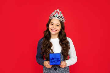 cheerful child in queen crown. princess in tiara hold box. kid with present.
