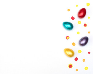 Obraz premium Bright painted easter eggs with paper flowers on white background. Happy Easter concept. Flat lay style with copy space