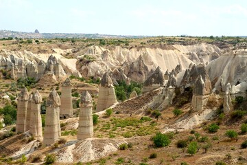 Hot air balloon flying over fairy chimneys and rock landscape at Cappadocia Turkey