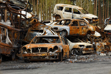 Fototapeta premium Dump of burnt civilian cars stolen, shoot by the Russian army and destroyed during Russia's war against Ukraine