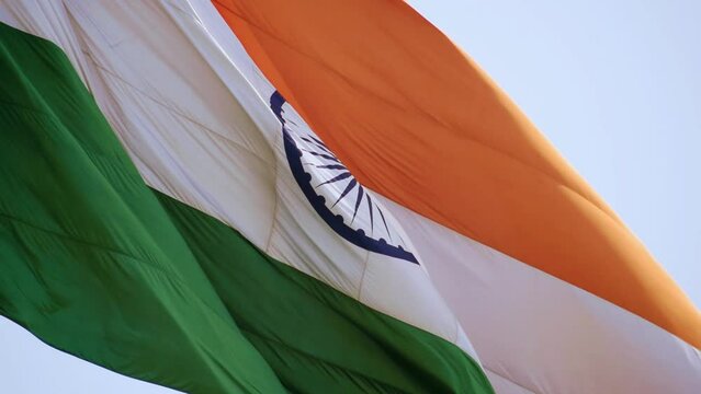 India flag flying high with pride in blue sky, India flag fluttering, Indian Flag on Independence Day and Republic Day of India, tilt up shot, waving Indian flag, Flying India flags