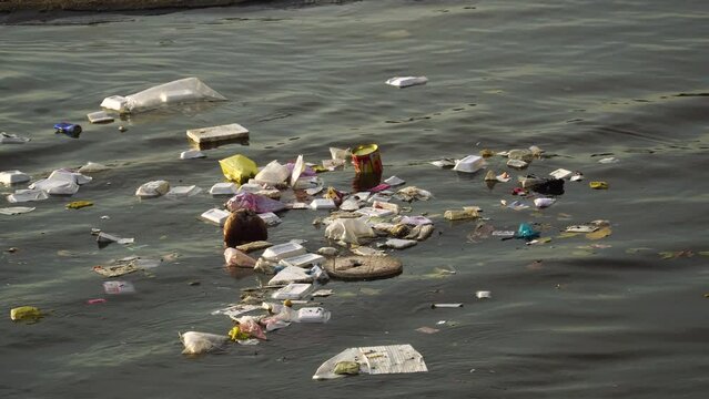 Close up, plastic garbage trash floating on river water