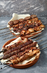 Overhead view of assortment of shashlik and kebabs over grey background