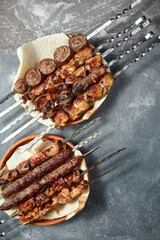 Overhead view of assortment of shashlik and kebabs over grey background