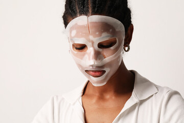 Young woman applies a hydro gel face mask. Skin care and beauty treatments