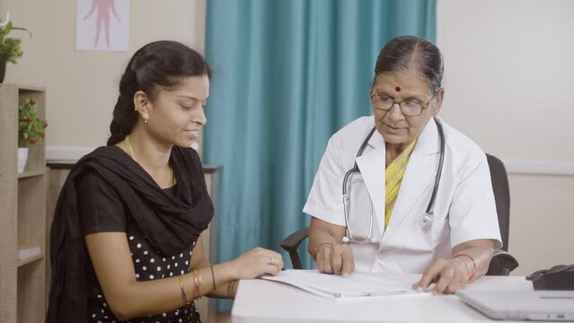female patient signing documents in front of doctor at hospital - concept of health insurance, and consent for policy
