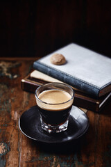 Coffee in glass cup on dark wooden background. Copy space.