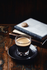 Coffee in glass cup on dark wooden background. Copy space.