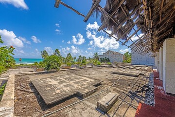 Picture of a destroyed, overgrown and left to itself hotel complex on a beach