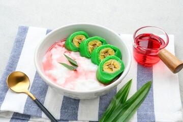 Es Pisang Ijo, traditional dessert from Makassar, South Sulawesi, Indonesia, made from banana which is rolled with a mixture of wheat flour, rice flour and coconut milk. Served with pureed and syrup.
