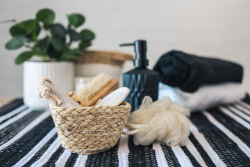 Fototapeta na wymiar Wicker basket with spa bathroom accessories, soap dispenser, towel, candle, brush
