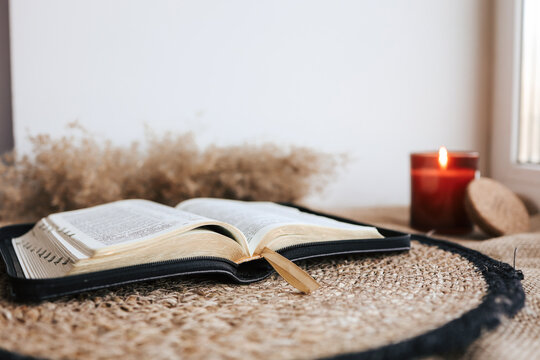 Open Holy Bible on a old wooden table and white wall background. Religion concept. Cozy warm photo