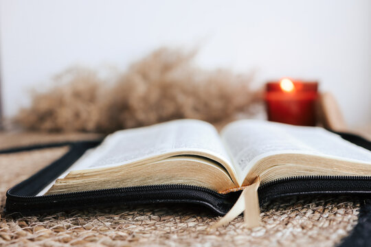 Open Holy Bible on a old wooden table and white wall background. Religion concept. Cozy warm photo