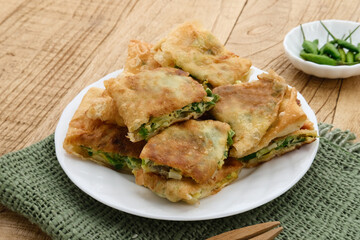 Martabak, Martabak Telor or Martabak Telur. Savory pan-fried pastry stuffed with egg, meat and spices. Martabak Telur is one of Indonesia street food. Served on white plate.

