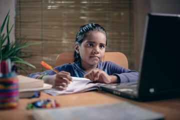 Indian girl student video conference e-learning with teacher and classmates on a smartphone in the living room at home. Homeschooling and distance learning, online, education, and internet.