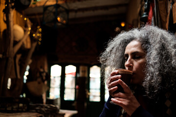 Mature woman having a mocha coffee in a cozy interior space.