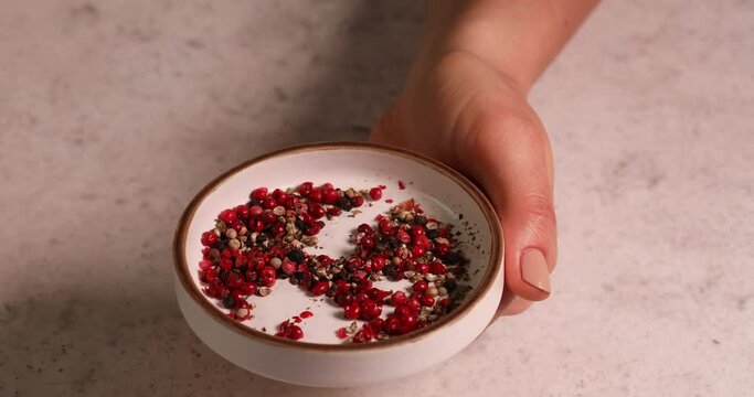 woman hand takes paprika hot pepper from bowl