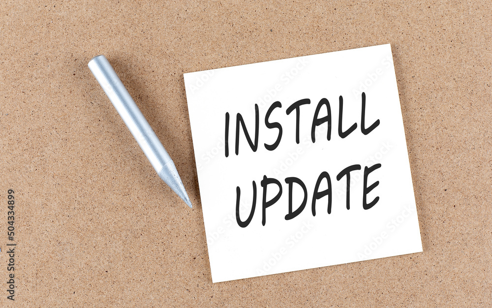 Poster install update text on a sticky note on a cork board with pencil ,