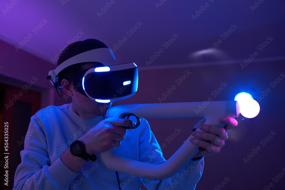 Wall mural man with virtual reality headset and joystic is playing game