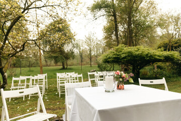 Fototapeta premium Chairs outside in the woods. Decoration for free weddings outside in the garden. Wedding in nature in spring