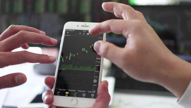 Securities investment managers look at and analyze stock data charts.